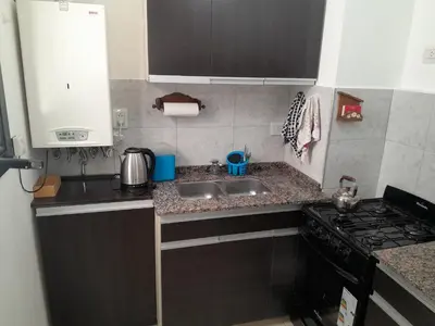 a small kitchen with a sink and a stove at Abuela Betty in Villa Carlos Paz