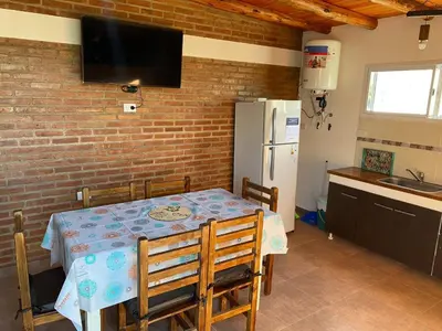 a kitchen with a table and a white refrigerator at El Rincon de las Marias Casa en Planta Alta in San Lorenzo