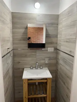 a bathroom with a sink and a brick wall at El Rincon de las Marias Casa en Planta Alta in San Lorenzo