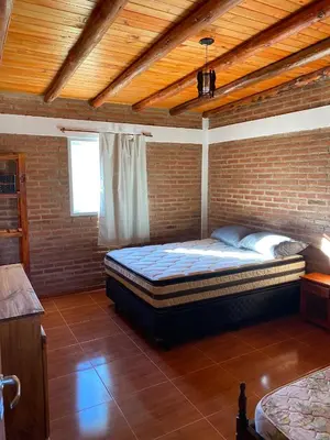a bedroom with a large bed in a brick wall at El Rincon de las Marias Casa en Planta Alta in San Lorenzo