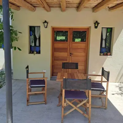 a wooden table and chairs in front of a house at la vinca serrana in San Javier