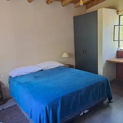 a bed in a room with a blue blanket on it at la vinca serrana in San Javier