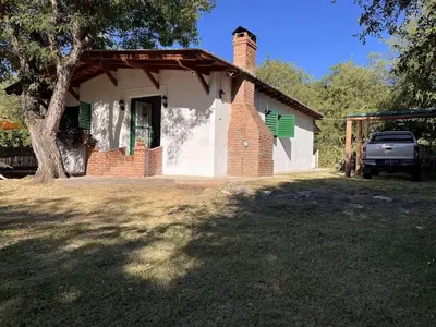 a brick house with a truck parked in front of it at Cabaña para Grupos en Córdoba Piscina y Asador in Yacanto