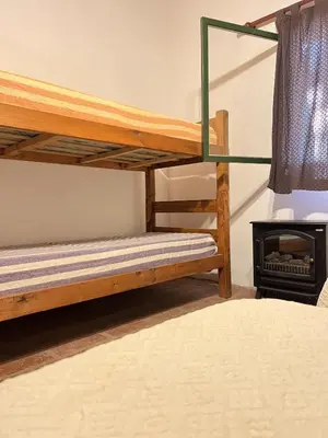 a bedroom with two bunk beds and a stove at Cabaña para Grupos en Córdoba Piscina y Asador in Yacanto