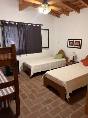 a bedroom with two beds and a ceiling at Cabaña para Grupos en Córdoba Piscina y Asador in Yacanto