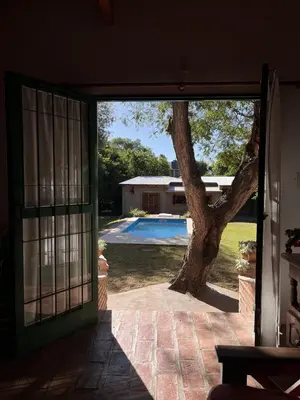 an open door of a house with a tree outside at Cabaña para Grupos en Córdoba Piscina y Asador in Yacanto