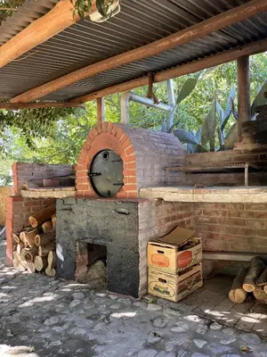 a brick oven sitting under a roof at Cabaña para Grupos en Córdoba Piscina y Asador in Yacanto