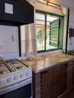 a kitchen with a stove and a counter top at Cabaña para Grupos en Córdoba Piscina y Asador in Yacanto