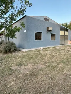 a gray house with a yard in front of it at La Fabrica in Yacanto