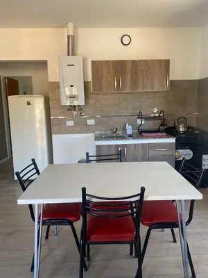 a kitchen with a white table and four chairs at Refugio Del Lago in Villa Carlos Paz