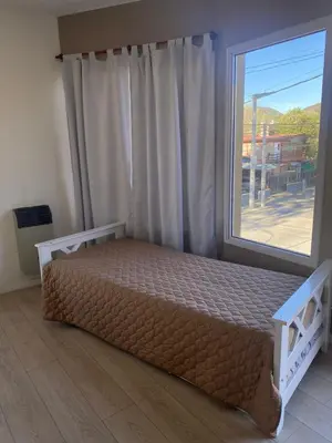 a bed in a room with a large window at Refugio Del Lago in Villa Carlos Paz