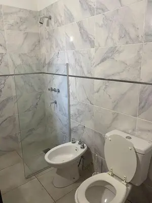 a bathroom with a toilet and a glass shower at Refugio Del Lago in Villa Carlos Paz