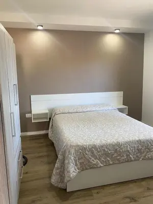 a bedroom with a bed and two lights on the wall at Refugio Del Lago in Villa Carlos Paz