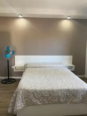 a bedroom with a bed and a fan at Refugio Del Lago in Villa Carlos Paz