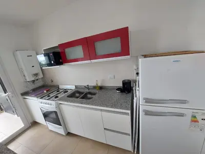 a kitchen with a white refrigerator and a stove at Departamento en Potrero de Garay in Potrero de Garay