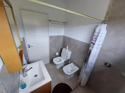 a bathroom with a toilet and a shower and a sink at Departamento en Potrero de Garay in Potrero de Garay
