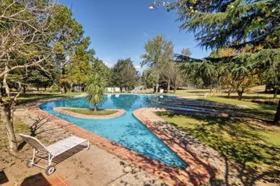 a swimming pool with a bench in a park at Departamento en Potrero de Garay in Potrero de Garay