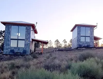 two small buildings sitting on top of a field at Eco Aldea in Villa Ciudad Parque