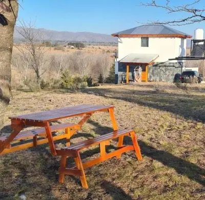 a picnic table and bench in front of a barn at Eco Aldea in Villa Ciudad Parque