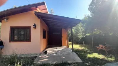 a house with a black cat sitting outside of it at CASA del RIO in Villa Ciudad Parque
