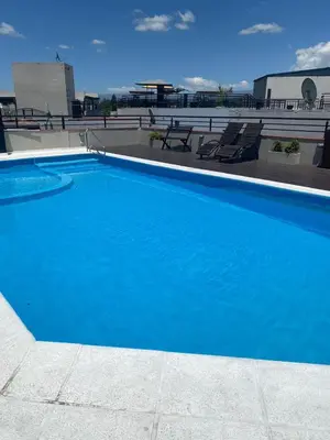 a large blue swimming pool on top of a building at Familiar Centrico PB Patio Cochera Amenities in Villa Carlos Paz