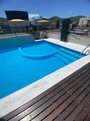 a blue swimming pool on top of a building at Familiar Centrico PB Patio Cochera Amenities in Villa Carlos Paz