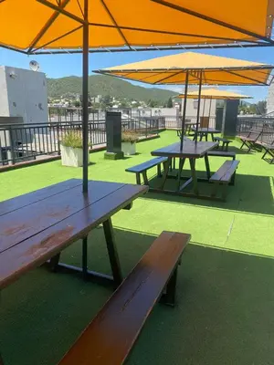 a group of picnic tables with umbrellas on a roof at Familiar Centrico PB Patio Cochera Amenities in Villa Carlos Paz