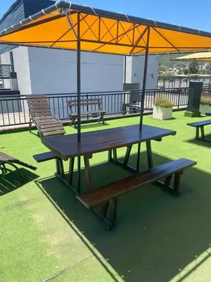a picnic table with an umbrella on a roof at Familiar Centrico PB Patio Cochera Amenities in Villa Carlos Paz