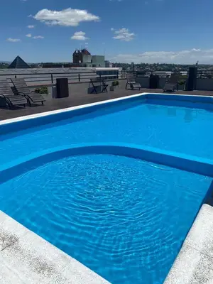 a large blue swimming pool on top of a roof at Familiar Centrico PB Patio Cochera Amenities in Villa Carlos Paz