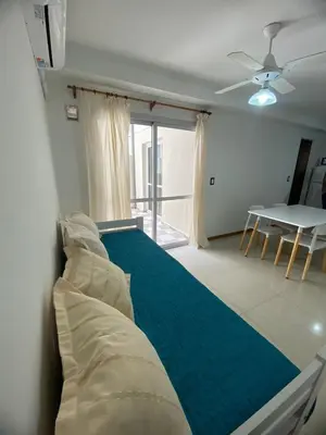 a bedroom with a bed and a table in it at Familiar Centrico PB Patio Cochera Amenities in Villa Carlos Paz