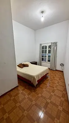 a bedroom with a bed and a wooden floor at Gran casa en Villa Del Lago in Villa Carlos Paz