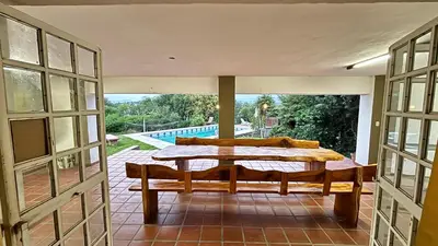 a porch with a bench and a view of a pool at Gran casa en Villa Del Lago in Villa Carlos Paz