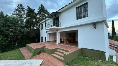 a white house with a patio in front of it at Gran casa en Villa Del Lago in Villa Carlos Paz