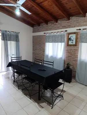 a dining room with a black table and chairs at Complejo La Luisina in Mina Clavero