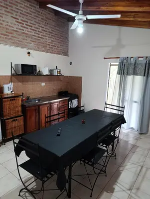 a dining room with a black table and chairs at Complejo La Luisina in Mina Clavero