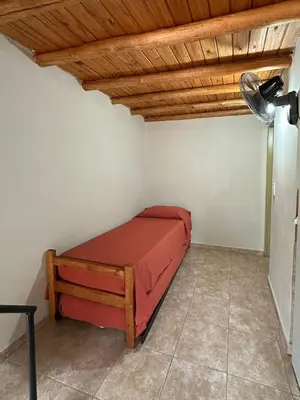 a bedroom with a red bed in a room at Complejo La Luisina in Mina Clavero