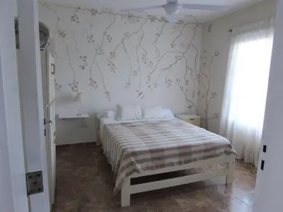 a bedroom with a bed and a wall with flowers at Casa Marie in Villa del Dique