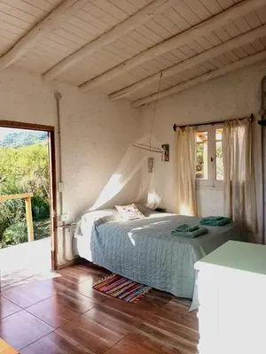 a bedroom with a bed and a large window at La calendula eco cabaña in Los Hornillos