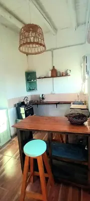 a kitchen with a wooden table and two stools at La calendula eco cabaña in Los Hornillos