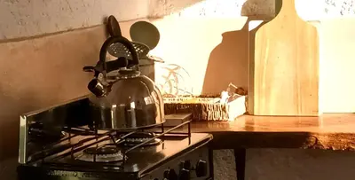 a tea kettle on top of a stove in a kitchen at La calendula eco cabaña in Los Hornillos