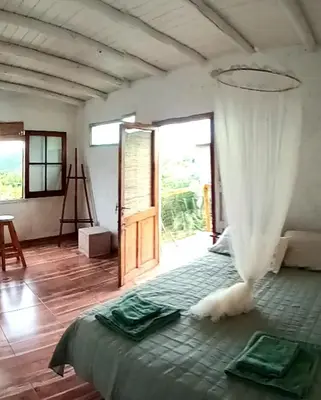 a bedroom with a bed in a room with a window at La calendula eco cabaña in Los Hornillos