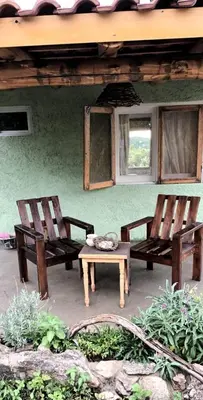 two chairs and a table in front of a house at La calendula eco cabaña in Los Hornillos