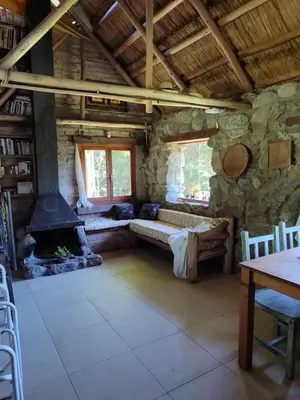a living room with a fireplace in a log cabin at Cabaña Maitane in El Durazno