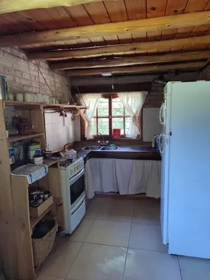 a kitchen with a white refrigerator and a stove at Cabaña Maitane in El Durazno