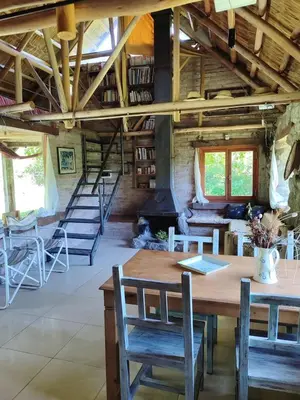 a dining room with a table and chairs and a fireplace at Cabaña Maitane in El Durazno