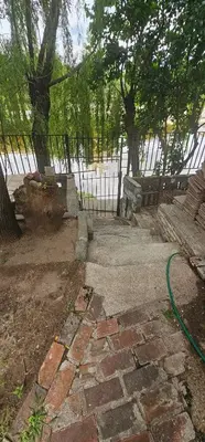 a garden with a fence and a green hose at Departamentos Las Termas de Brochero in Villa Cura Brochero