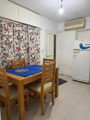 a kitchen with a table and chairs and a refrigerator at Departamentos Las Termas de Brochero in Villa Cura Brochero
