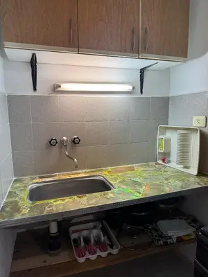 a kitchen counter with a sink and a microwave at Departamentos Las Termas de Brochero in Villa Cura Brochero