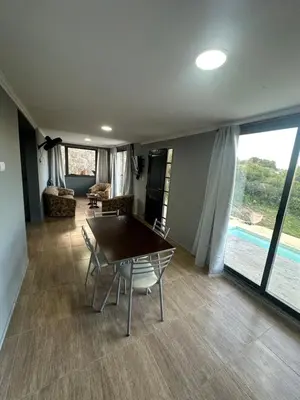 a dining room with a table and chairs in a house at Lo de joel in Villa Carlos Paz