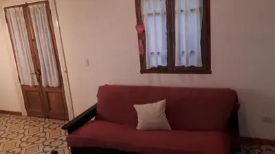 a living room with a red couch and a mirror at La arbolada in Villa Ciudad Parque
